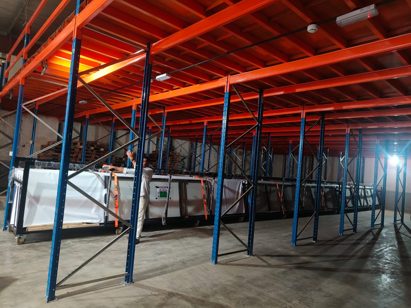 Strapping large crated panels onto warehouse mezzanine racking